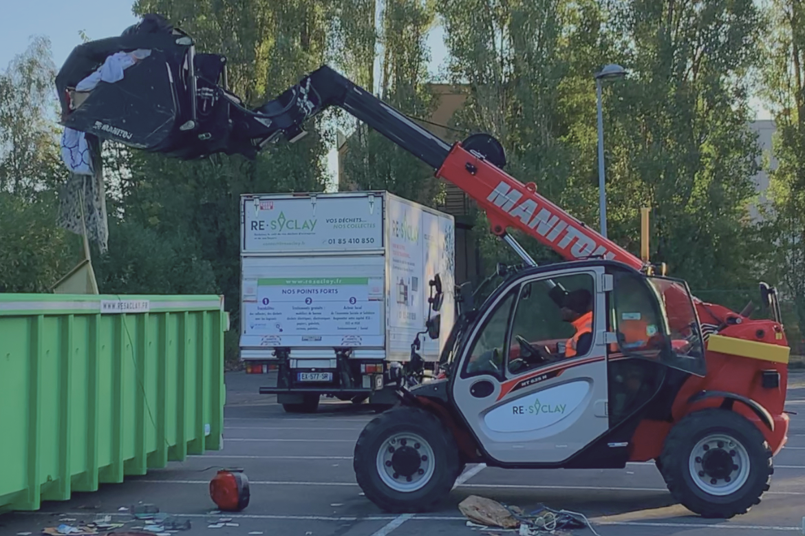 Manitou soulevant des déchets